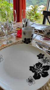 einen Tisch mit einem weißen Teller mit schwarzen Blumen drauf in der Unterkunft TIVA PERL LODGE TAHAA in Tiva