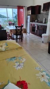a kitchen and dining room with a table with a yellow towel at TIVA PERL LODGE TAHAA in Tiva