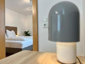 una camera d'albergo con un letto e una lampada su un tavolo di Stadthaus 1911 a Bludenz