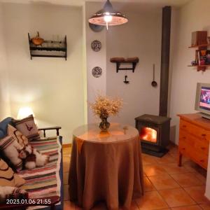 a living room with a table and a fireplace at Apartamento vacacional en la Alpujarra in Laroles