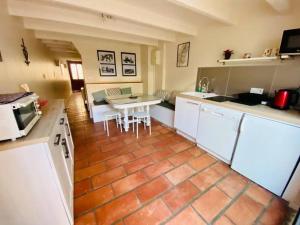 eine Küche mit einem Tisch und einer Arbeitsplatte in der Unterkunft La Saline in Aigues-Mortes