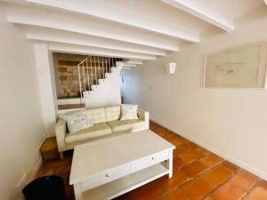 ein Wohnzimmer mit einem Sofa und einer Treppe in der Unterkunft La Saline in Aigues-Mortes