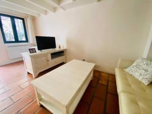 ein Wohnzimmer mit einem Sofa und einem Flachbild-TV in der Unterkunft La Saline in Aigues-Mortes