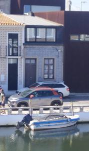 una piccola barca in acqua accanto a un'auto di A Casa da Joana ad Aveiro Altre 4 foto