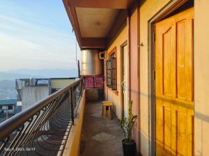 einen Balkon eines Gebäudes mit einer Tür und einer Pflanze in der Unterkunft Studio Unit with Own Cr & Kitchen - Unit 303 in Baguio City