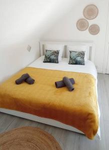 a bedroom with a bed with two slippers on it at Le p’tit Kerf proche Centre Ville in Quimper