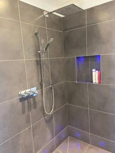 a bathroom with a shower with a shower head at Stunning town centre apartment with sea views in Worthing