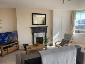 a living room with a fireplace and a tv at Stunning town centre apartment with sea views in Worthing