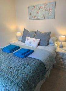 a bedroom with a bed with blue sheets and pillows at Stunning town centre apartment with sea views in Worthing