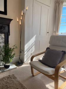 a living room with a chair and a fireplace at Stunning town centre apartment with sea views in Worthing