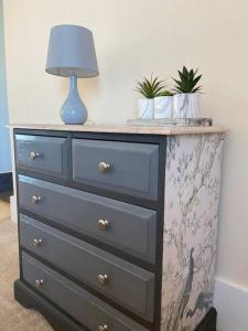 a dresser with a blue lamp on top of it at Stunning town centre apartment with sea views in Worthing