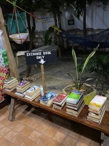 une table avec des livres et un panneau dans l'établissement HOMELAND SWAHILI LODGE Nungwi Backpacker Apartments BUDGET, à Nungwi