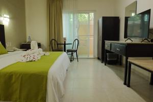 Habitación de hotel con cama y escritorio en Hotel Chablis Palenque en Palenque