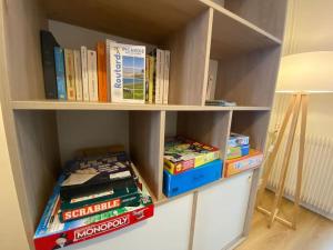 a book shelf filled with lots of books at Maison de Charme - 4 Chambres - Courette & Parking Gratuit in Amiens