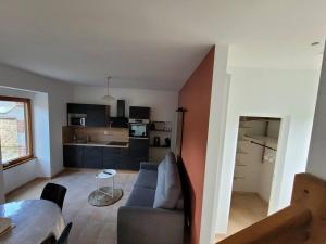 een woonkamer met een bank en een tafel bij Logement 2 à 4 pers - moulin in Saint-Carreuc