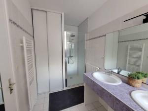 uma casa de banho com um lavatório e uma cabina de duche em vidro. em Logement 2 à 4 pers - moulin em Saint-Carreuc