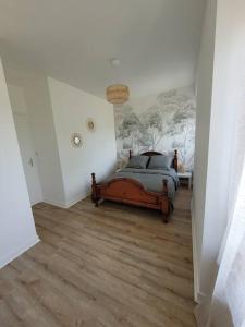 um quarto com uma cama com um quadro na parede em Logement 2 à 4 pers - moulin em Saint-Carreuc