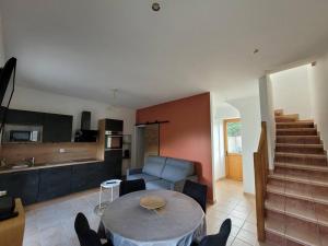uma cozinha e sala de estar com uma mesa e um sofá em Logement 2 à 4 pers - moulin em Saint-Carreuc
