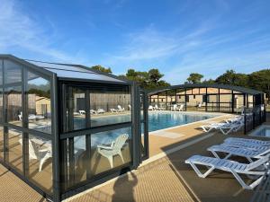 un pavillon avec des chaises et une piscine dans l'établissement Cottage parc résidentiel de loisir, à Saubrigues