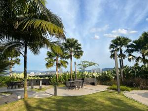吉隆坡的住宿－Eaton Residence KLCC BY Galaxy Suites，一座公园,公园内有桌子和棕榈树,后面有一座城市