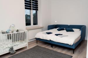 een blauw bed in een kamer met een wieg bij Downtown Apartments in Bremen