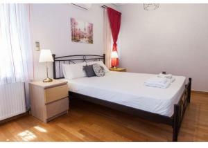 een slaapkamer met een groot bed met witte lakens bij Luxury 2BR Retreat in Marousi in Athene