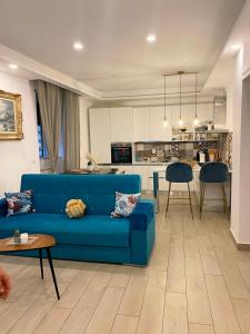 a living room with a blue couch and a kitchen at Fifi Home in Pozzuoli