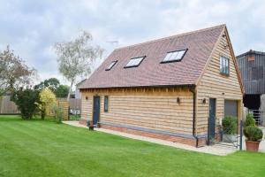 a large wooden house with windows on a lawn at Nr Bicester Village 5 Star Luxury on farm in Piddington