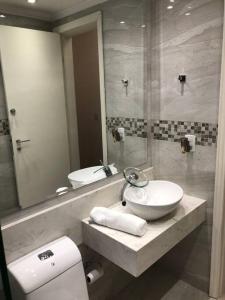 La salle de bains est pourvue d'un lavabo, de toilettes et d'un miroir. dans l'établissement Beverly Hills House, à Curitiba