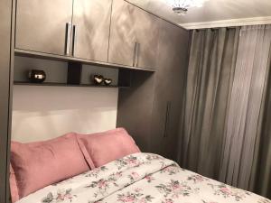 1 dormitorio con 1 cama con almohadas y armarios rosas en Beverly Hills House, en Curitiba