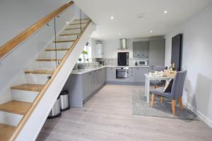 een keuken en eetkamer met een trap in een huis bij Nr Bicester Village 5 Star Luxury on farm in Piddington