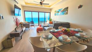 una sala de estar con mesa y sillas y el océano en Oceandreams 3br 2ba - New Condo - Fantastic Views en Isla Mujeres