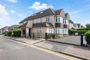 a house with a black fence in front of a street at Luxury Apartment in Town Centre with Free Gated Parking in Potters Bar