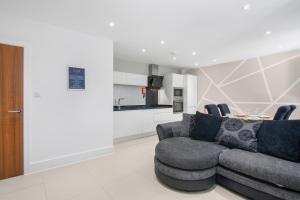 a living room with a couch and a table at Luxury Apartment in Town Centre with Free Gated Parking in Potters Bar
