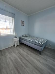 ein Schlafzimmer mit einem Bett in einem Zimmer mit einem Fenster in der Unterkunft ALEX - bright, stylish apartment with sauna, built in 2023 in Närpiö