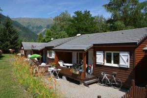 a cabin with a bike parked in front of it at A La Rencontre Du Soleil - Camping in Le Bourg-dʼOisans