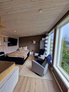 - une chambre avec un lit, un lit et une chaise dans l'établissement Sjarmerende anneks i Sigerfjord, Vesterålen, à Sortland