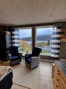 a living room with two chairs and a large window at Sjarmerende anneks i Sigerfjord, Vesterålen in Sortland