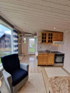 Sjarmerende anneks i Sigerfjord, Vesterålen في سورتلاند: غرفة معيشة مع كرسي ومطبخ