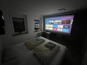 Schlafzimmer mit einem Bett und einem Flachbild-TV in der Unterkunft LittleHome in Hornberg