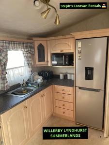 a kitchen with a refrigerator and a sink at WILLERBY LYNDHURST in Lincolnshire