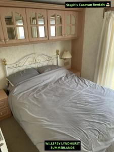 a bedroom with a large bed with a white comforter at WILLERBY LYNDHURST in Lincolnshire