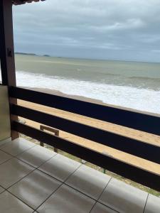 a view of the ocean from a balcony at Casa de Praia PÉ NA AREIA em Rio das Ostras RJ in Rio das Ostras