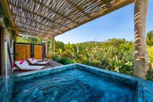 an outdoor swimming pool with a pergola and a swimming poolvisor at W Punta de Mita in Punta Mita