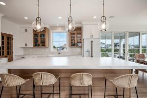 een keuken met een groot wit eiland met stoelen bij MyLBIBeachRental, 6 from Beach, 6 Bedroom, 4.5 Bath, Sleeps 12, New Construction in Long Beach