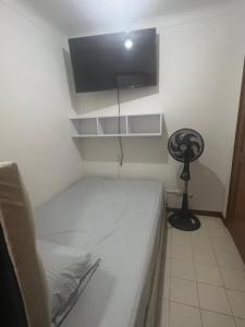 a small bedroom with a bed and a fan at Apartamento en el ingenio 2 in Cali