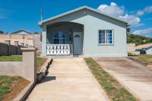 a small blue house with a porch and a driveway at El Casa Azul in Discovery Bay