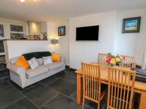 uma sala de estar com um sofá e uma mesa em Potters Cottage em Lynton