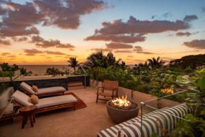 eine Terrasse mit einer Feuerstelle und dem Meer bei Sonnenuntergang in der Unterkunft W Punta de Mita in Punta Mita