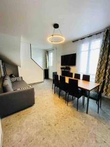 ein Wohnzimmer mit einer Couch und einem Tisch und Stühlen in der Unterkunft Entire residence Stade de France in Aubervilliers